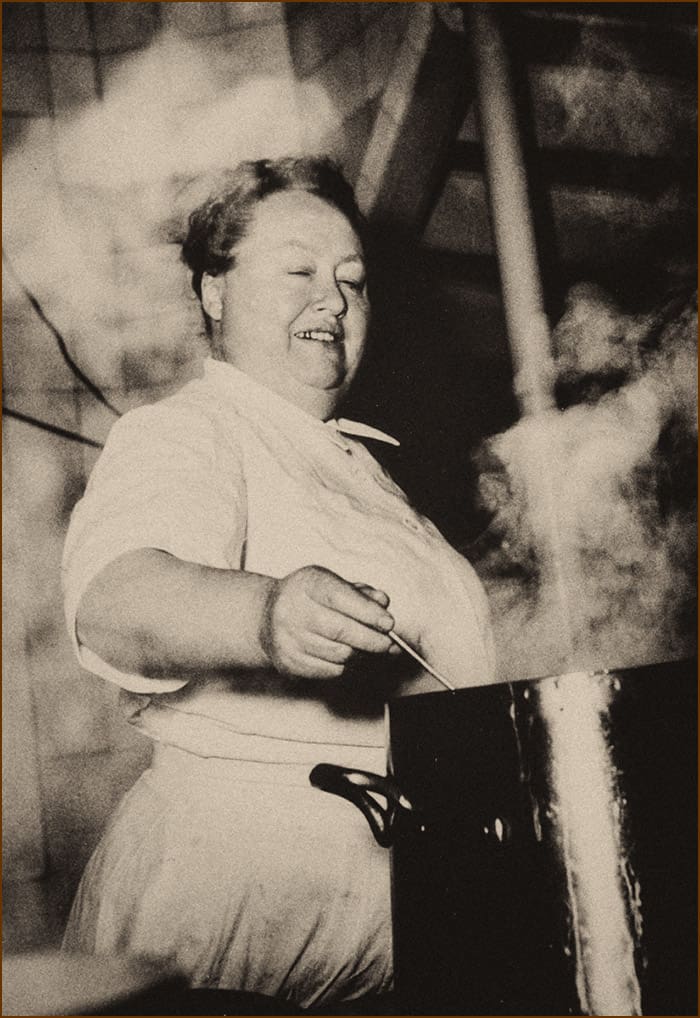 Eugénie Brazier in her kitchen with steaming pots